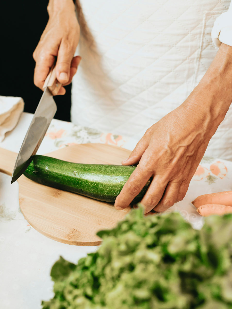 Frau schneidet Zucchini