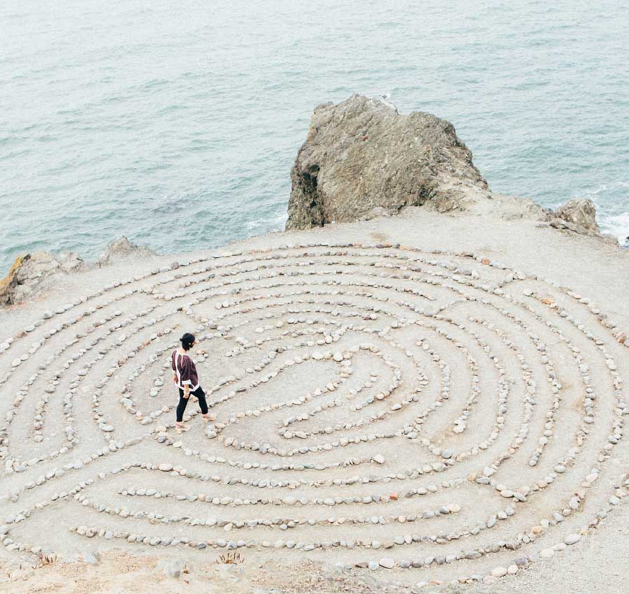 Gesunder Lebensstil: Mentale Gesundheit und Mindset Mann am Meer läuft über Steinkreis – Mentale Stärke und Mindset für ein gesundes Leben